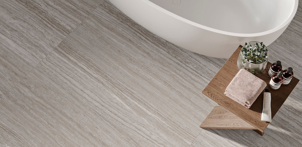 Modernes Badezimmer mit Azuvi Atlantis Feinsteinzeugfliesen in Taupe, matte Marmoroptik als Bodenbelag neben freistehender Badewanne, rektifiziertes Format 60×120 cm mit ruhiger, eleganter und natürlicher Raumwirkung.