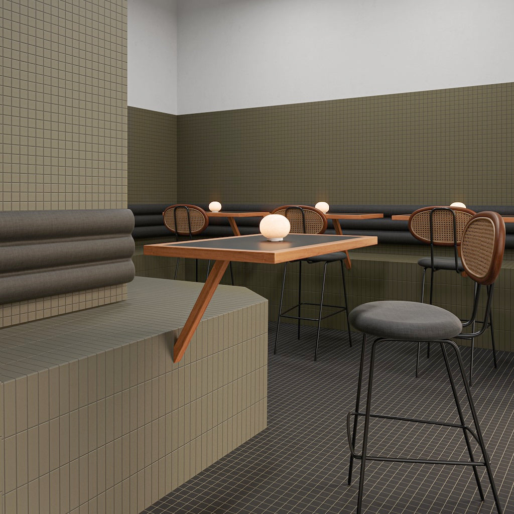 Sitzbereich mit WOW Raster Fliesen in Moss und Basalt, Kombination aus Lines- und Grid-Struktur an Wand und Podest, matte Keramikfliesen in handgemachter Optik mit klarer, geometrischer Raumwirkung.