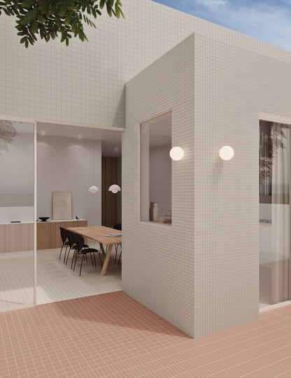 Architektonischer Innenhof mit WOW Raster Fliesen in Chalk und Mud, Kombination aus Grid- und Lines-Struktur an Fassade und Boden, matte Keramikfliesen in handgemachter Optik mit klarer, geometrischer Raumwirkung.