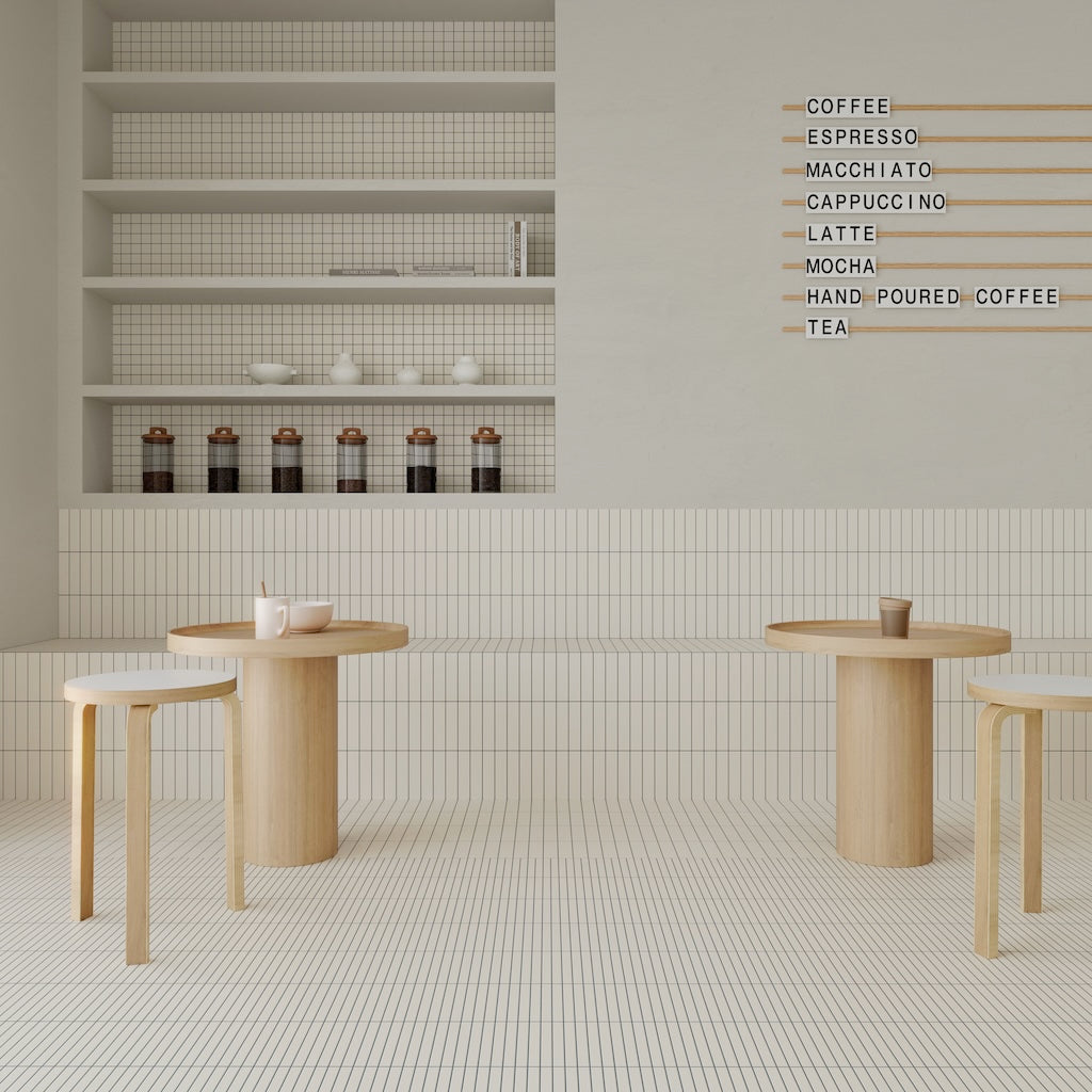 Café-Interieur mit WOW Raster Fliesen in Chalk, Kombination aus Lines- und Grid-Struktur an Wand und Boden, matte Keramikfliesen in handgemachter Optik mit klarer, geometrischer Raumwirkung.