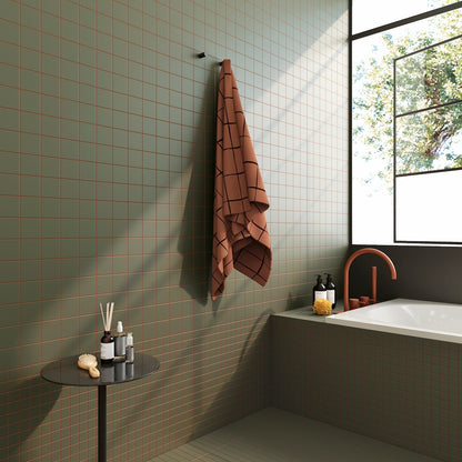 Badezimmer mit WOW Raster Fliesen in Moss-Grün, geometrisches Rasterdesign an Wand und Badewanne, matte Keramikfliesen mit moderner Architekturwirkung und natürlichem Lichteinfall.